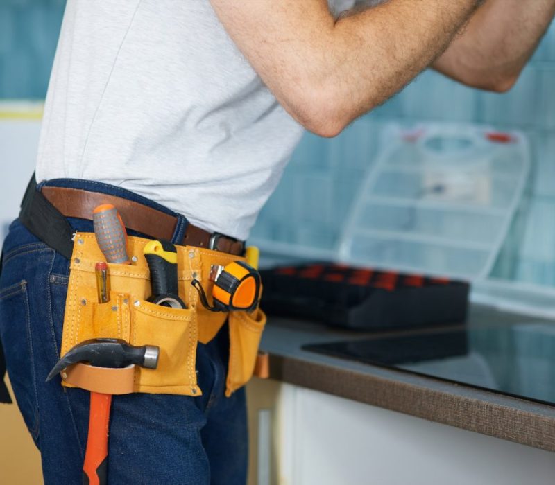 reliable-repairs-cropped-shot-of-young-handyman-wearing-a-tool-belt-fixing-a-kitchen-extractor.jpg